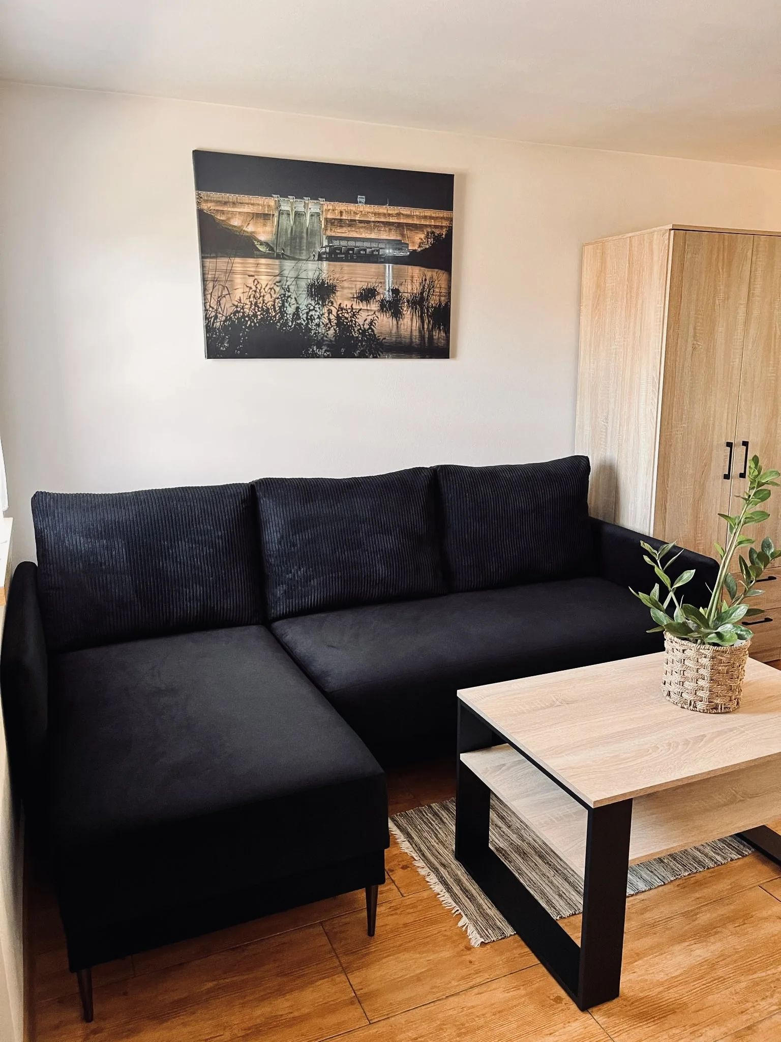 Salon z czarną kanapą w domku